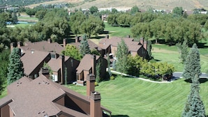 A residential area with multiple houses, a golf course, and a hilly landscape in the background. - Spacious Park City 4BR, Walk to Three Kings Lift, Mountain Views, Pool  & Hot Tu (Park City)