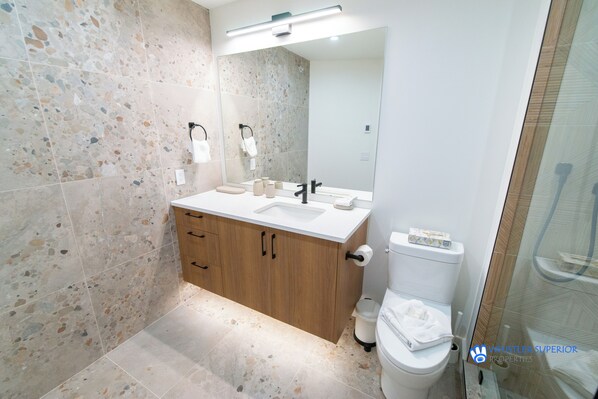 A modern bathroom with a freestanding sink, a toilet, and a shower area. - Upgraded Whistler Village Condo. BBQ on the Deck, Pool and Hot Area (Whistler)
