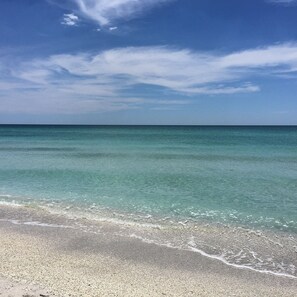 Ein Strand mit klarem türkisblauem Wasser und Kiesstrand.