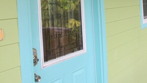 A turquoise door with a fish-shaped decoration and a window with a metal grill.