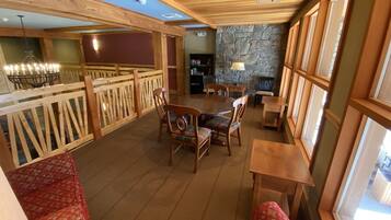 A cozy restaurant with wooden furniture, stone walls, and large windows.