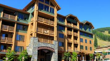 A multi-story hotel with a stone facade, balconies, and a sign reading "Morning Eagle."