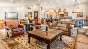A spacious living room with leather sofas, a wooden coffee table, and a large rug. - Fantastic Mountain Townhome! Shared Hot Tub! Pool Table! Views! (Mammoth Lakes)