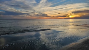 A beach with a sunset, calm water, and a clear sky. - Inn at Dauphin Island 411 Beautiful Unit with Incredible Views!! (Dauphin Island)