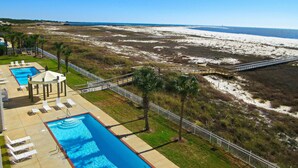 A resort with a swimming pool, lounge chairs, and a beach view. - Inn at Dauphin Island 411 Beautiful Unit with Incredible Views!! (Dauphin Island)