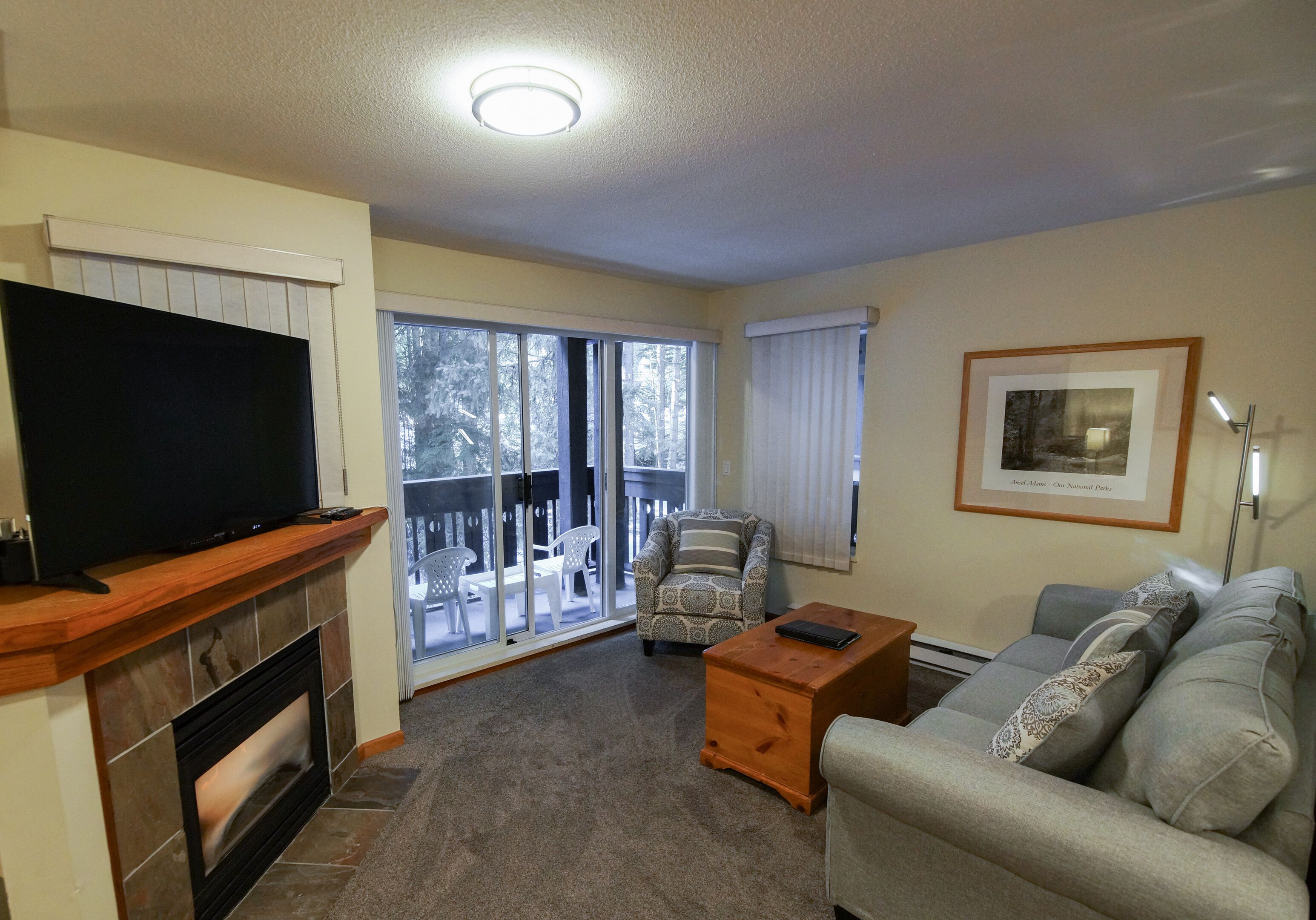A living room with a television, sofa, coffee table, and a fireplace.