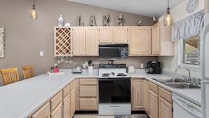 A modern kitchen with wooden cabinets, a microwave, stove, and a sink.