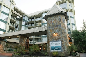 A multi-story hotel with a stone facade and a sign reading 'Woodrun on Blackcomb.'