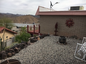Enjoy panoramic views of the surrounding mountains from this rooftop patio, featuring a grill, chair, and decorative sculpture.