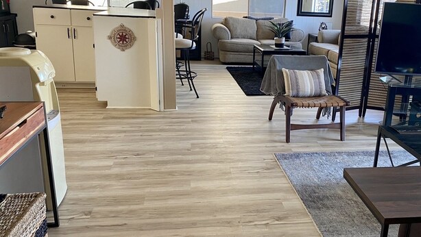 A spacious living area with a kitchen, a dining area, and a seating area with a sofa and armchairs. - Lake view home with mountain views by Havasu Springs (Parker)