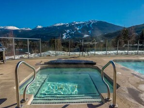 A pool with clear water, metal railings, and a mountain view in the background. - Modern Blueberry Condo, Private Hot Tub, BBQ, Best View in Whistler, Pool (Whistler)