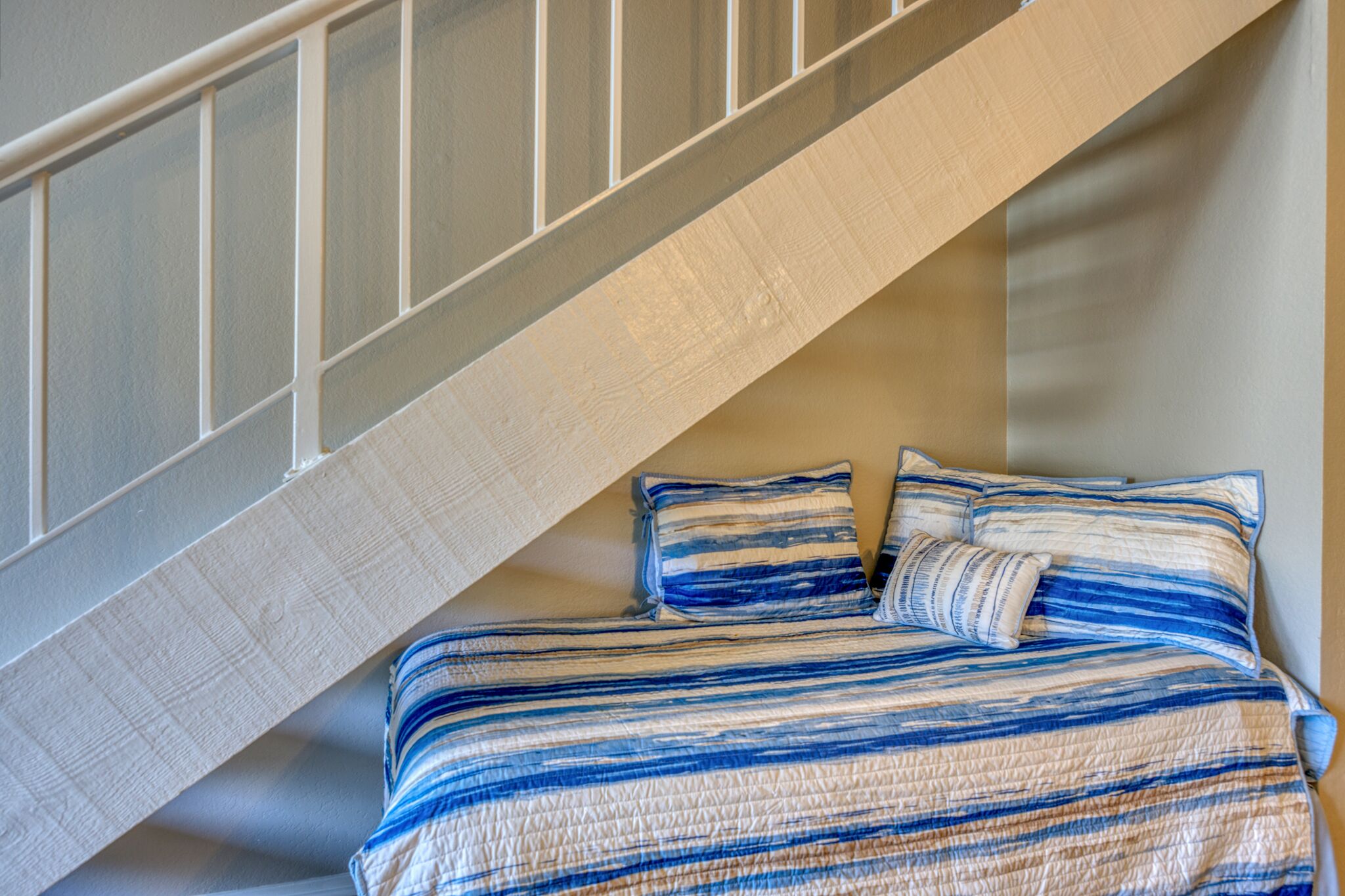Une chambre à coucher avec un lit, deux oreillers et un escalier en bois.