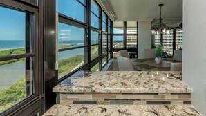 A kitchen with a large window overlooking a river and a cityscape.