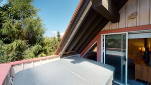 A room with a large sliding glass door, a wooden bench, and a view of trees. - Stoney Creek Sunpath 47 (Whistler)