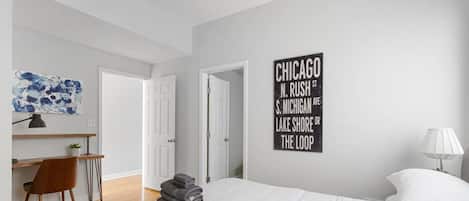 2 habitaciones, escritorio y tabla de planchar con plancha