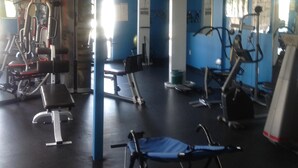 Ginásio com diversos equipamentos de exercício, incluindo esteiras e máquinas de musculação.