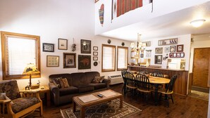 Ein Wohnzimmer mit Sofa, Couchtisch und Essbereich mit Stühlen und Tisch.