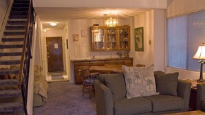 A living room with a staircase, a dining area, and a kitchen. - A01: 2 Bedroom, 2.5 Bath, Townhouse Style Condo (Avalon)