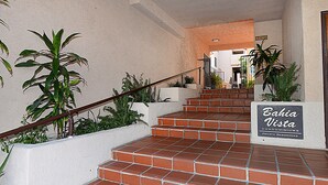 A staircase with red tiles leading to a door marked "Bahia Vista Condominiums Private Residences". - A01: 2 Bedroom, 2.5 Bath, Townhouse Style Condo (Avalon)