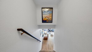 A staircase leading to a living area with a framed artwork above.