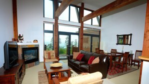 A spacious living room with a fireplace, a leather sofa, and a dining area.