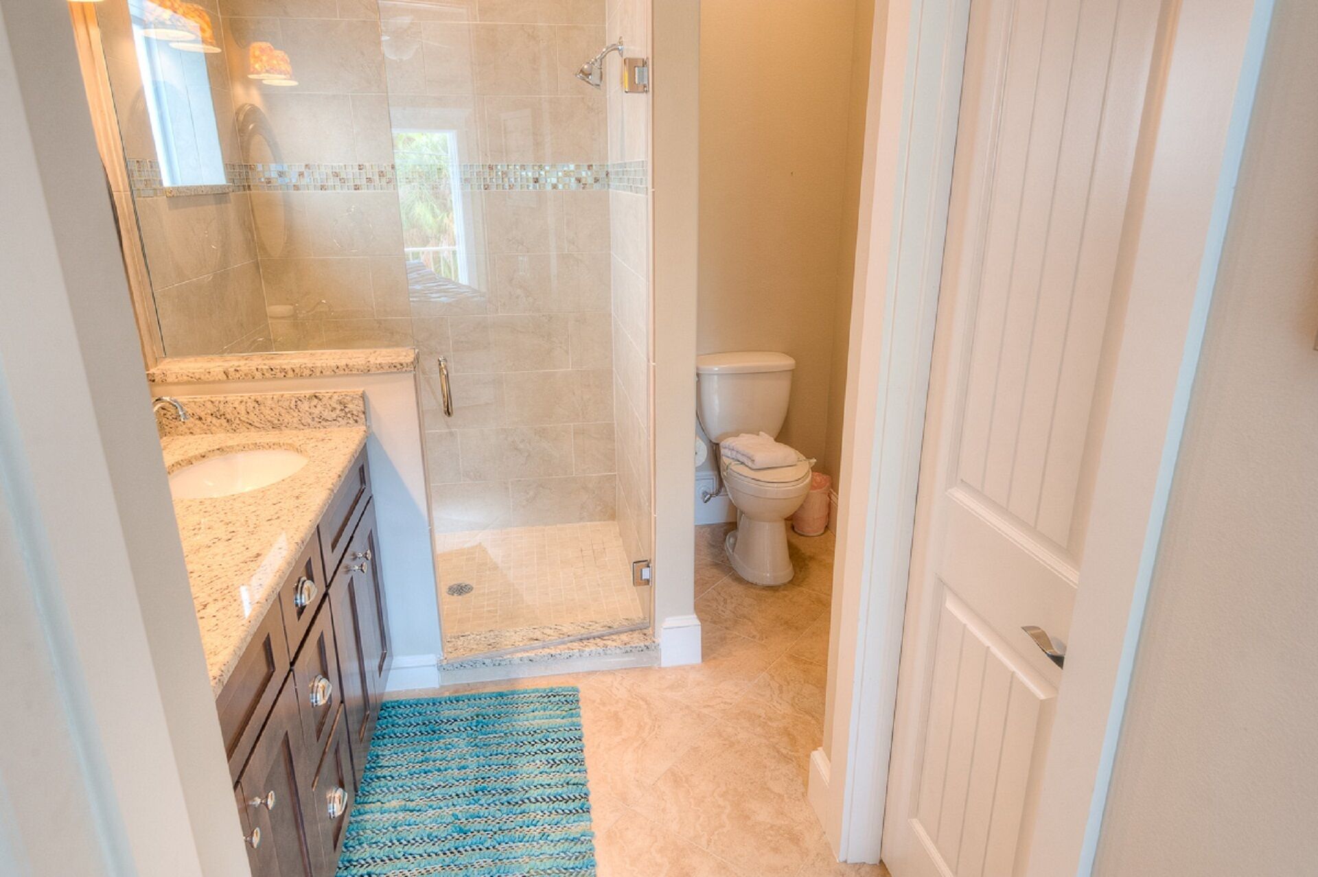 A bathroom with a shower, toilet, and sink.
