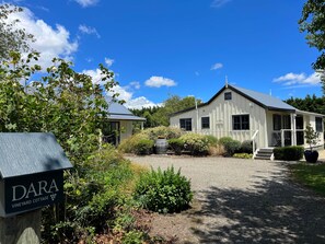 A white building with a porch and a sign that reads "DARA VINEYARD COTTAGE". - Dara Vineyard Cottage Martinborough (Martinborough)