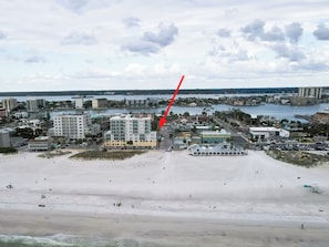 Un paysage urbain côtier avec une plage, des bâtiments et un port de plaisance.