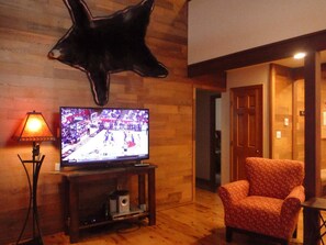 Relax in this inviting living area with a flat-screen TV, comfortable seating, and a cozy atmosphere.