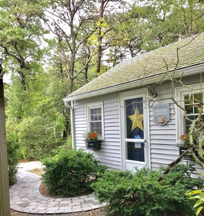 Un chalet agrémenté d’une enseigne accueillante, d’une décoration en forme d’étoile et d’un chemin menant à l’entrée.