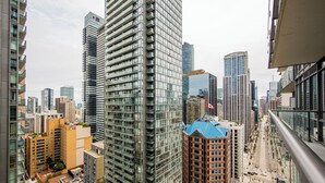 Un edificio de gran altura con fachada de vidrio moderna, rodeado de otros edificios altos en un entorno urbano.