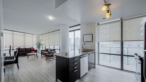 Un apartamento moderno con cocina, sala de estar y grandes ventanales con vistas a la ciudad.