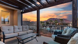 A balcony with a sofa, wicker chairs, and a pool view. - PVZ 33|Steps to Pools *Misters* Pool/Mtn PatioView (Santa Clara)