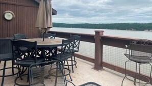 Terraza con mobiliario exterior, un reloj y vistas al lago.