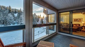 Una habitación con amplios ventanales que ofrecen vistas a un paisaje nevado y un edificio a lo lejos.