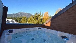 Un jacuzzi con vista a la montaña y árboles.