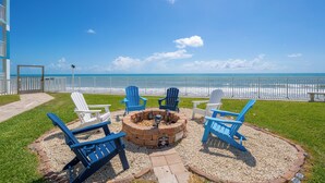 A beachside patio with Adirondack chairs, a fire pit, and a view of the ocean. - Steps from Pool & Beach, Oceanfront ground floor condo, Unit 106 (Satellite Beach)