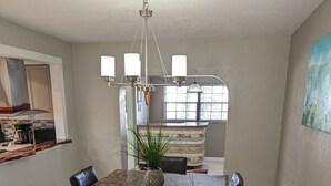 A dining area with a marble table, dark chairs, a patterned rug, and a hanging light fixture. - Stay 5 Nights, Get 1 Night Free - 4 BR home in quiet setting close to everything (Port Orange)