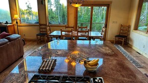 A spacious kitchen with a central island, large windows, and a dining area with wooden furniture. - One of the Most Desirable Properties in the Winter Park / Fraser Valley (Tabernash)