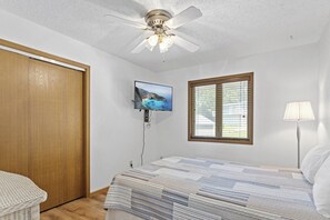 A bedroom with a bed, a ceiling fan, a TV, a window with blinds, and a lamp. - Teak Village 3 - 44 - Three Bedroom House, Sleeps 10 (Lake Ozark)