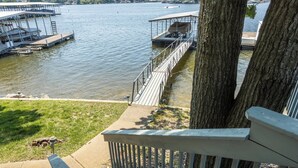 Ein Steg am Seeufer mit Holzterrasse, Überdachung und Blick auf das Wasser.