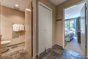 A bathroom with a toilet, a towel rack, and a shower area. - Greystone Lodge 202 Ski-in/Out by Acer Vacations (Whistler)