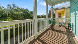 A covered porch with a white railing, potted plants, and a bench. - Patriot's Eden: Golf, Water Park, Near Disney (Kissimmee)