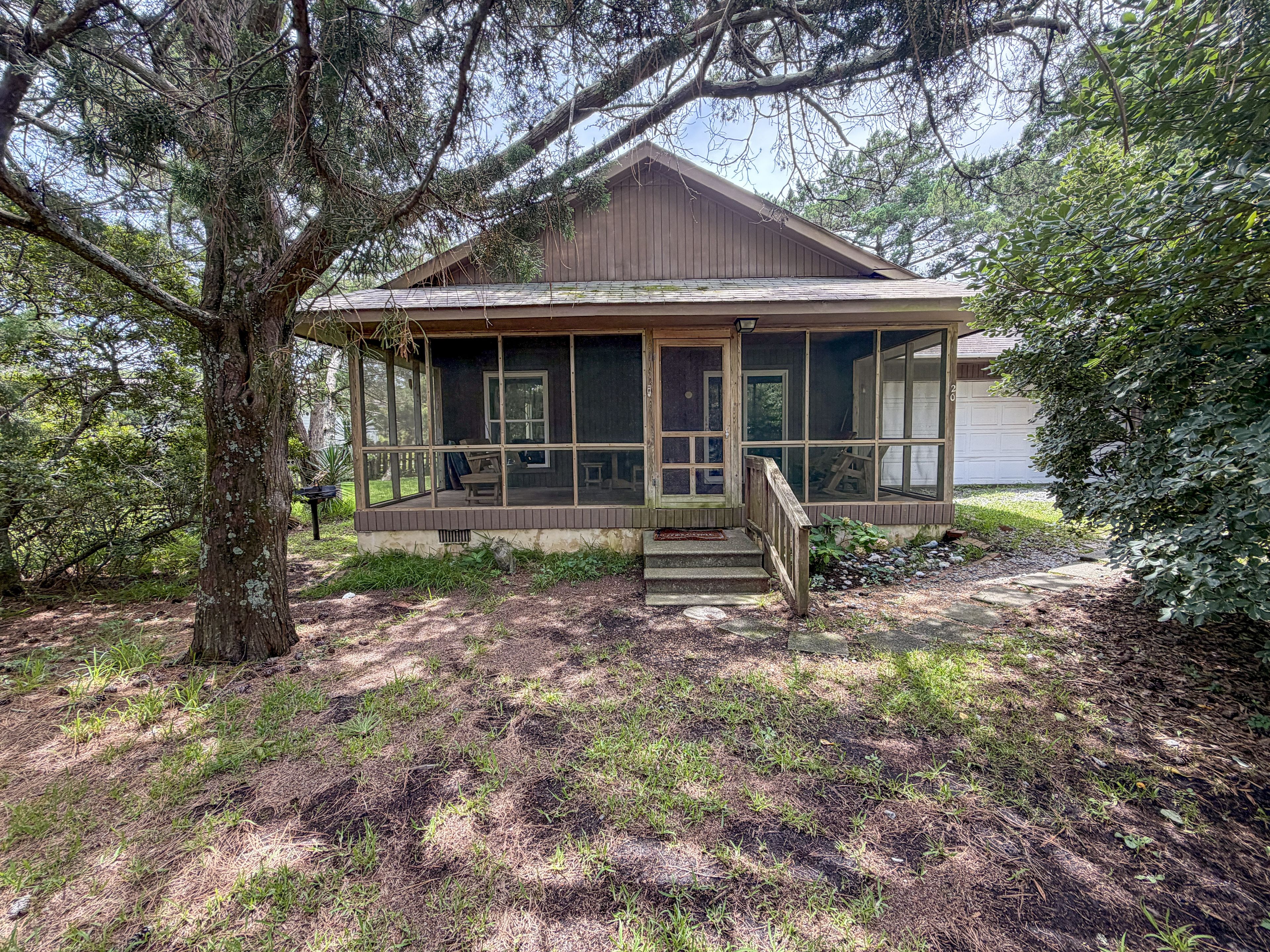 A cabin with a porch, a covered deck, and a garage.