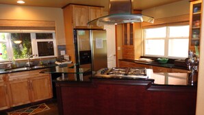 Una cocina moderna con una isla central, electrodomésticos de acero inoxidable y armarios de madera.
