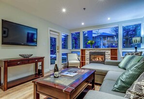 A living room with a fireplace, a television, a sofa, and a coffee table.