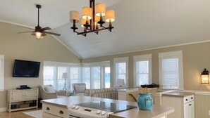 A kitchen with a central island, a ceiling fan, and a built-in oven.