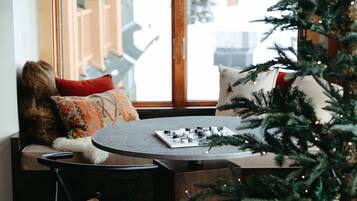 Un coin salon accueillant avec un banc en bois, une petite table et un sapin de Noël.