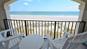 Un balcon avec vue sur une plage et l’océan.