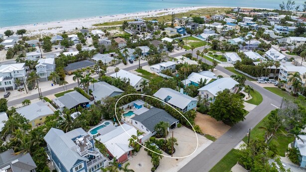 Un quartier résidentiel situé sur la côte, avec des maisons, une plage et une vue dégagée sur l’océan.